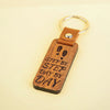 Wooden keychain with engraved text on a beige background